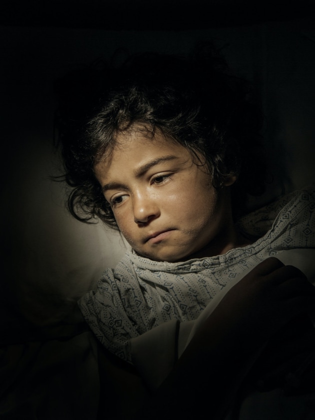 © Adam Ferguson. Bibi Najla, 7, lies in a hospital bed recovering from a bullet wound. She was shot during fighting between Taliban and government forces in Logar Province, Afghanistan, 2016.