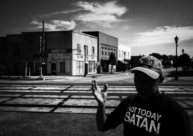 NOT TODAY SATAN, WILSON NC. This image was made during the Eyes on Main Street residency in Wilson North Carolina. Wilson has an incredible number of churches. This guy was at the train station taking a break from a long train trip to cross the continent for a new job. Image: Meg Hewitt