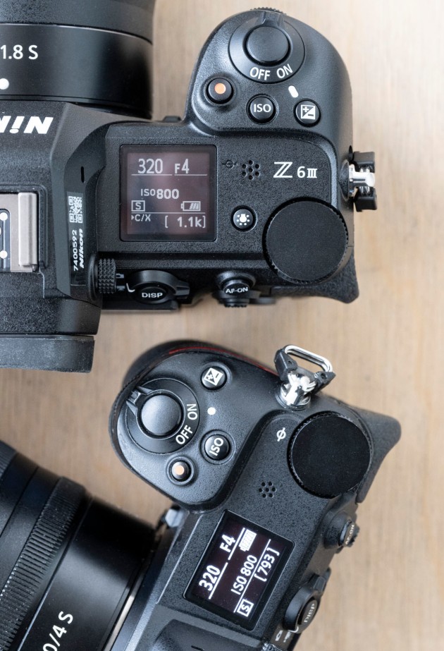 The top deck of the Nikon Z6 III (at top) is almost identical to the Z6 deck (below) aside from the slightly bigger LCD and an Illumination button that is used to turn on and off the back lighting on the new display.