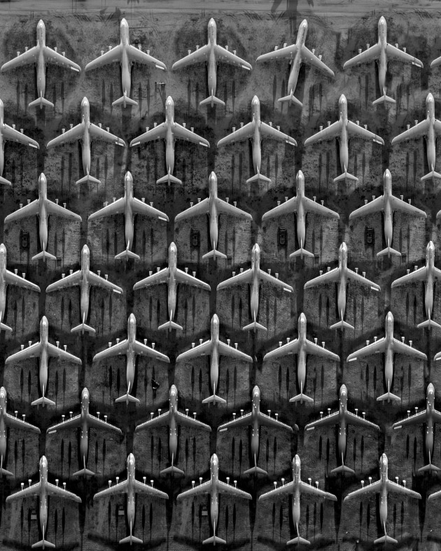 © Jason M. Peterson. Grave Robbing. Over the airplane graveyard in Tucson, Arizona. Every dead plane in the perfect place, with just one not willing to die.