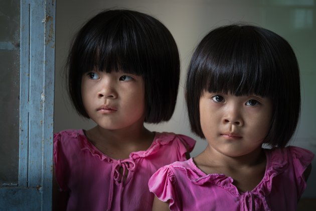 © Simon Lister. Twins waiting in line at a health clinic, Mekong River, Vietnam.