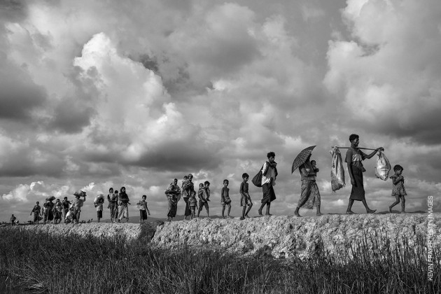 Rohingya Refugees Flee Into Bangladesh to Escape Ethnic Cleansing. &copy; Kevin Frayer, Getty Images.
GENERAL NEWS - SECOND PRIZE, STORIES
Attacks on the villages of Rohingya Muslims in Myanmar, and the burning of their homes, led to hundreds of thousands of refugees fleeing into Bangladesh on foot or by boat. Many died in the attempt. According to UNICEF, more than half of those fleeing were children. In Bangladesh, refugees were housed in existing camps and makeshift settlements. Conditions became critical; basic services came under severe pressure and, according to a M&eacute;decins Sans Fronti&egrave;res physician based there, most people lacked clean water, shelter and sanitation, bringing the threat of disease.
2 October 2017. Rohingya refugees carry their belongings as they walk on the Bangladesh side of the Naf River after fleeing Myanmar.